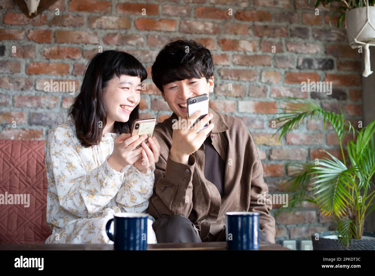 Couple looking at their phones at home Stock Photo