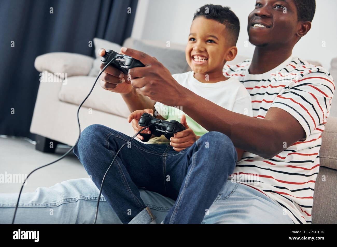 Playing video games. African american father with his young son at home  Stock Photo - Alamy