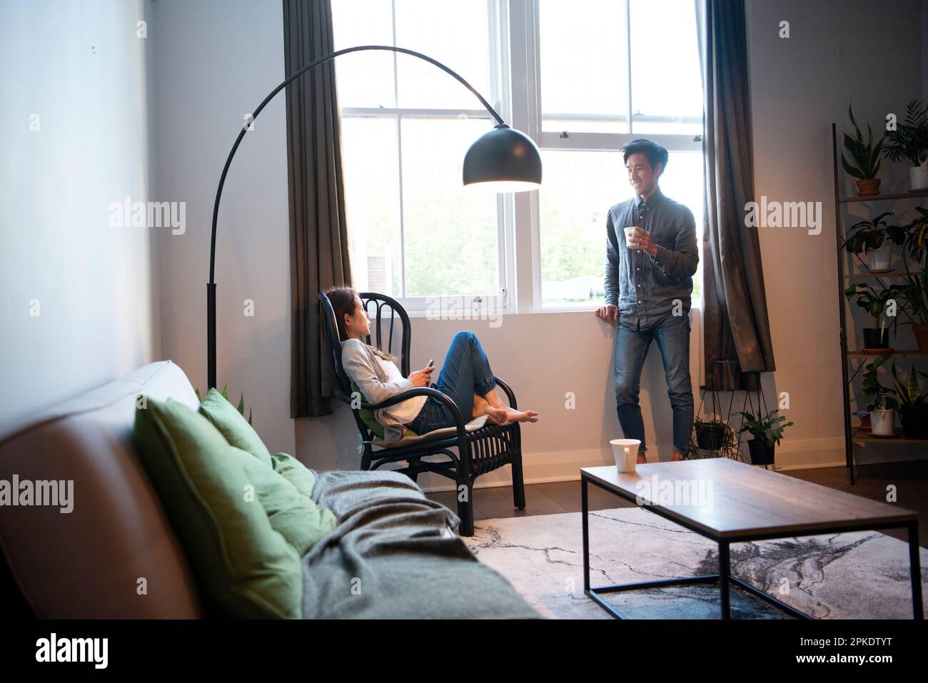 Couple relaxing in living room while talking Stock Photo