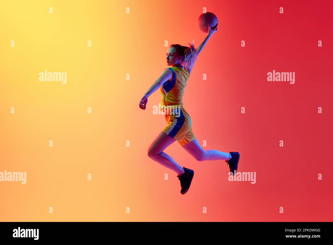 Slam dunk. Dynamic image of active female basketball player in motion during game throwing ball
