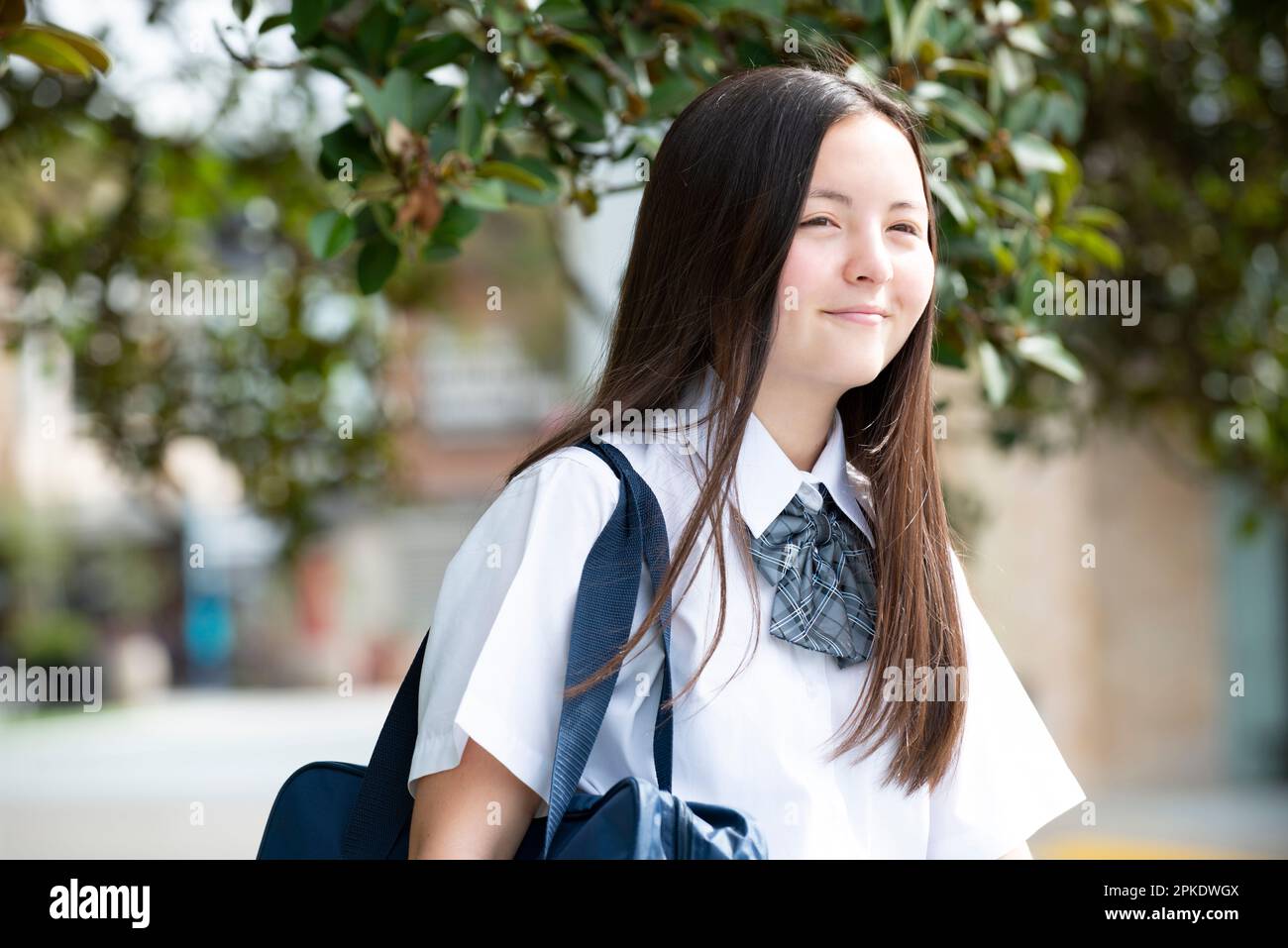 Schoolgirl in school uniform smiling Stock Photo - Alamy