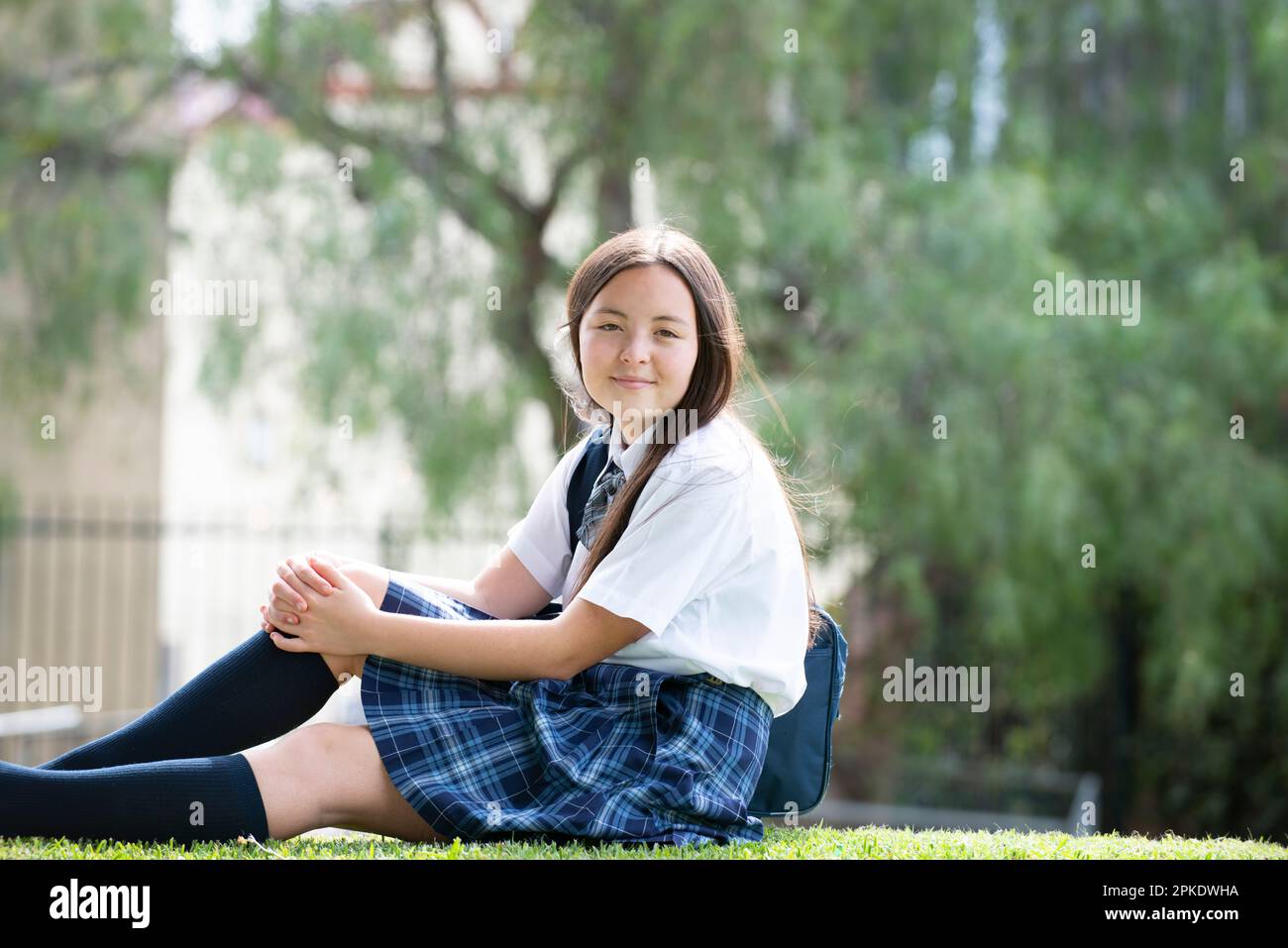 A female student in school uniform sitting on the lawn Stock Photo - Alamy
