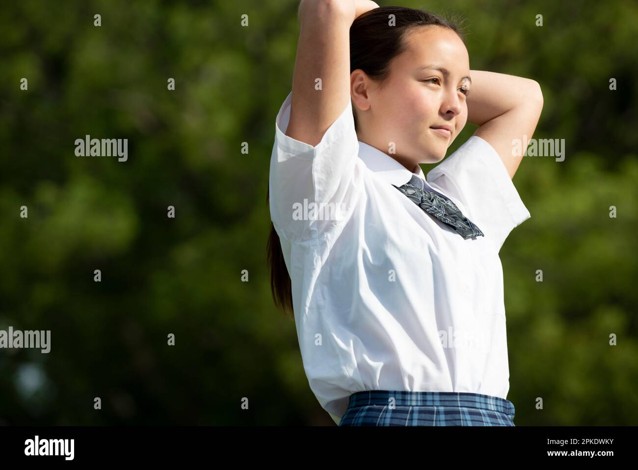 Curated visual reference: Female Student In School Uniform Tying Her Hair Stock Photo Photo Inspiration