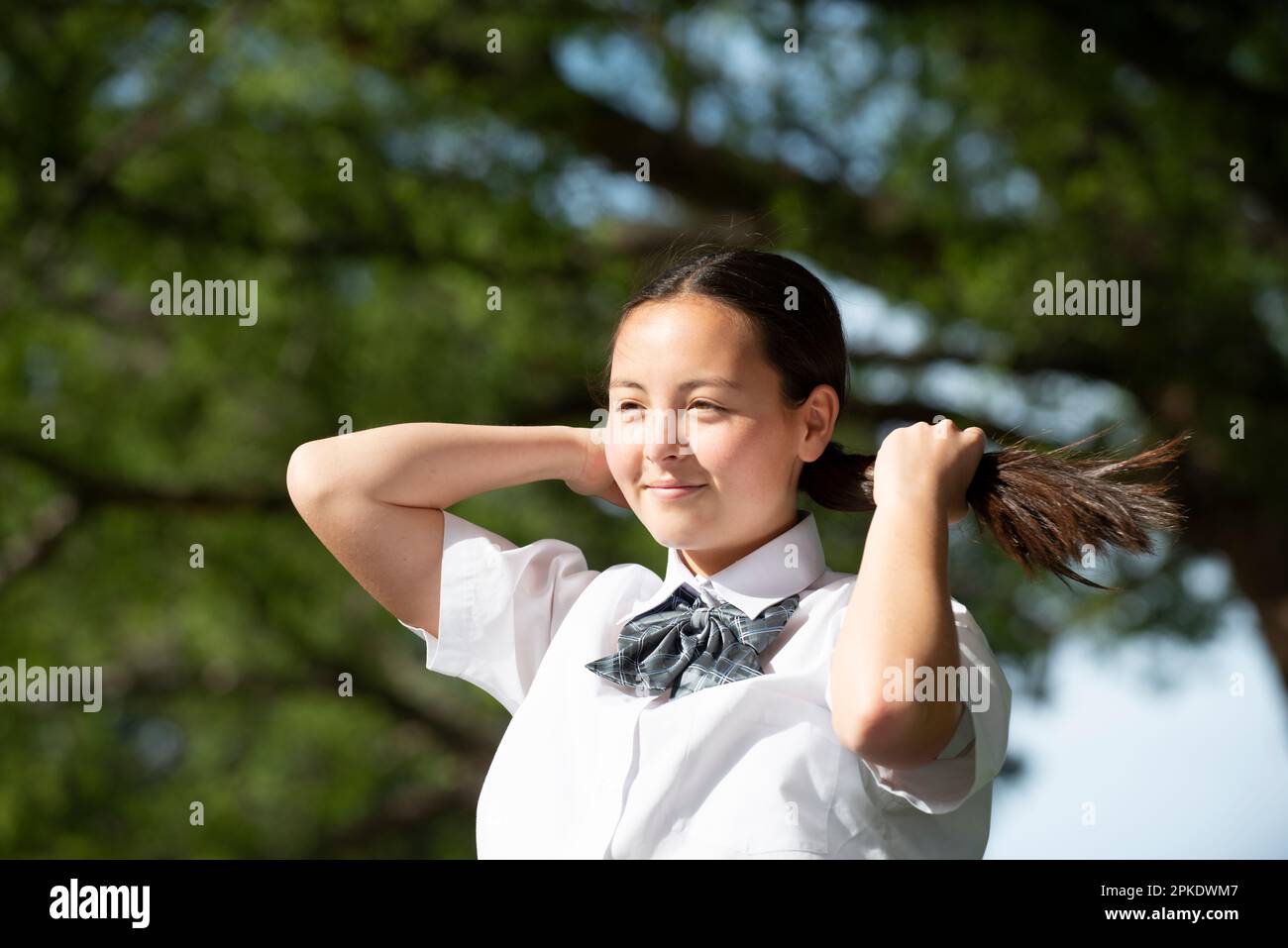 Fastest Tying For School Uniforms Reference: Female Student In School Uniform Tying Her Hair Stock Photo