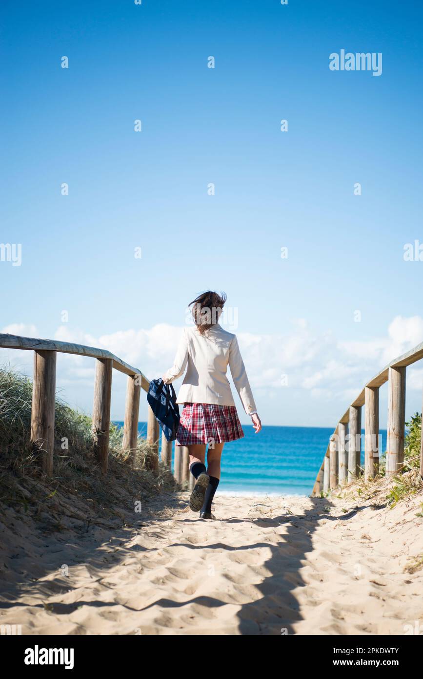 Schoolgirl in school uniform running Stock Photo Alamy