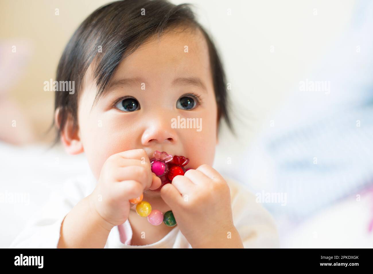 Baby with toy in mouth Stock Photo