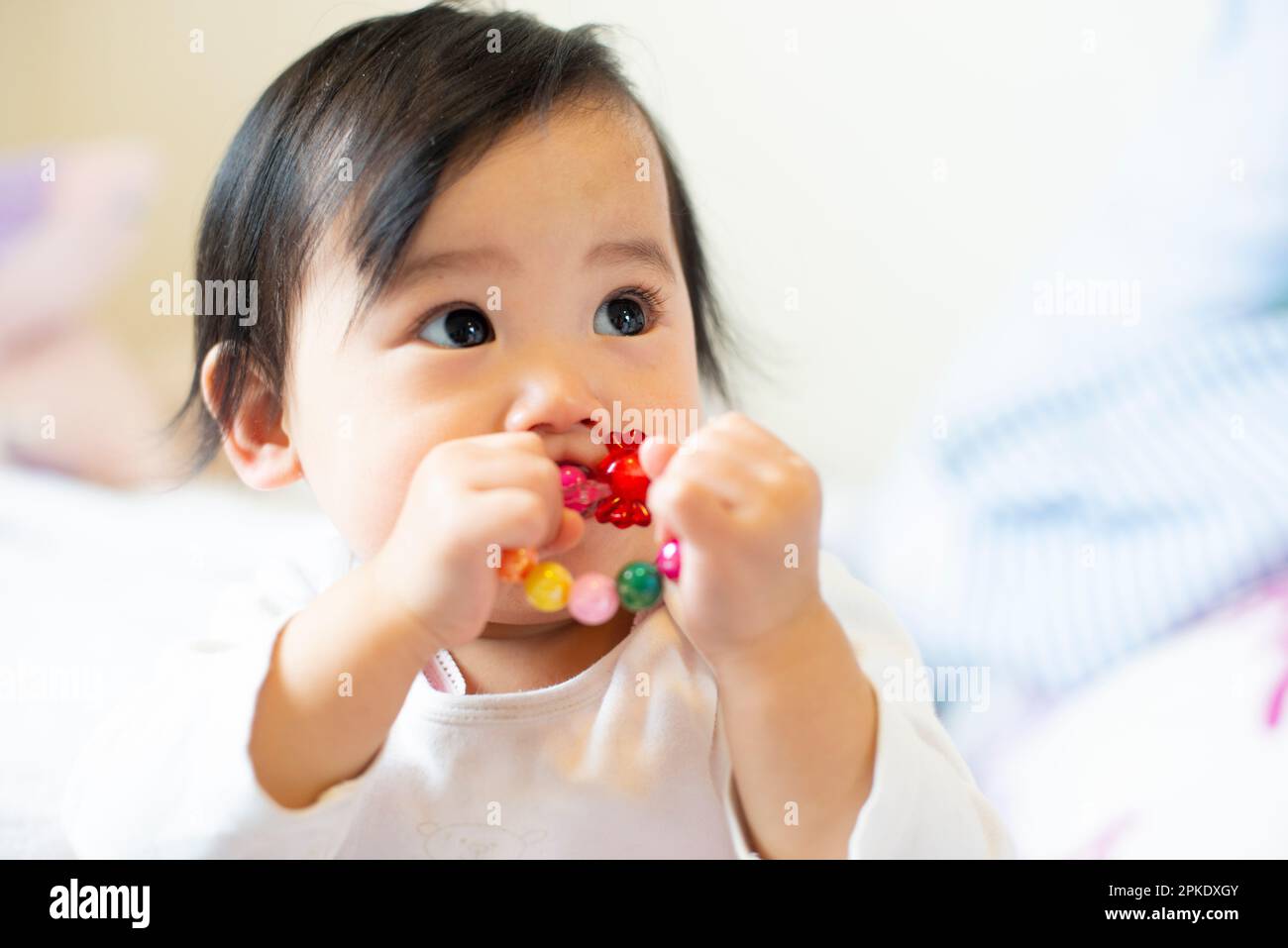 Baby with toy in mouth Stock Photo