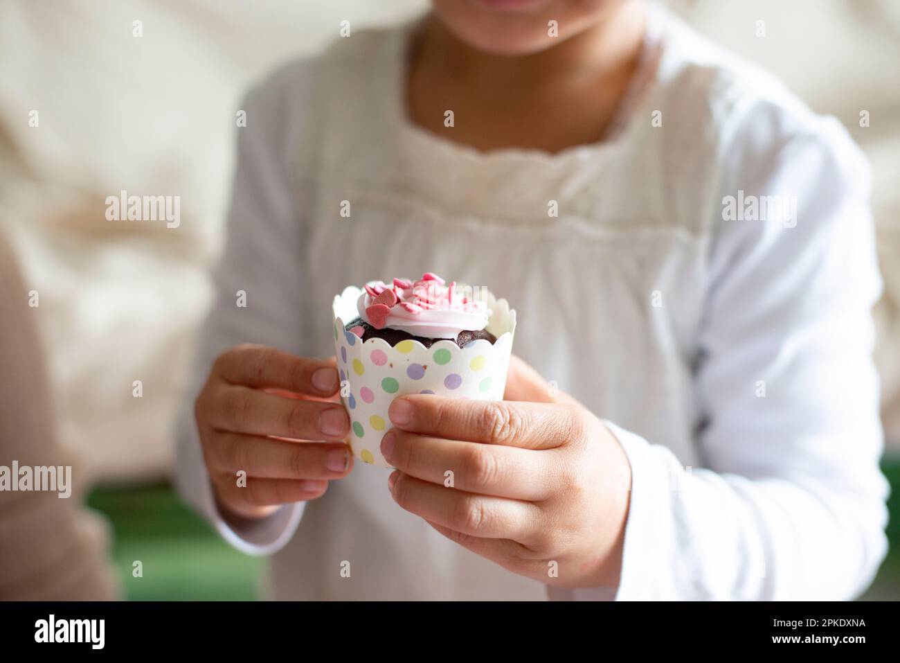 Girl holding cupcake in hand Stock Photo Alamy
