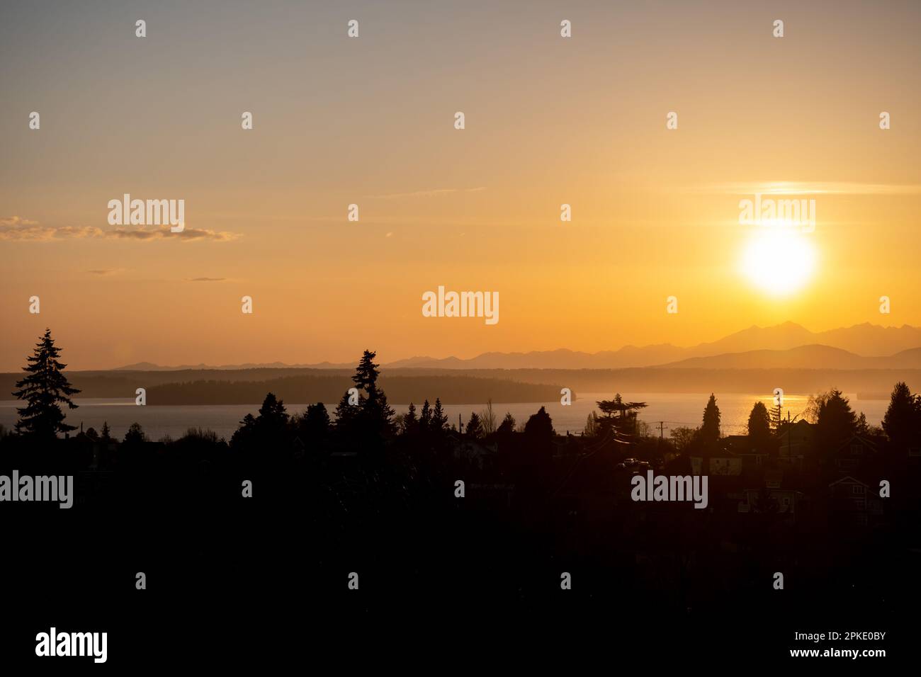 The sunset over the Olympic Mountain Range in Washington State as viewed from West Seattle Stock Photo