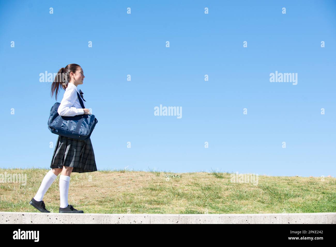 Schoolgirl in school uniform walking Stock Photo - Alamy