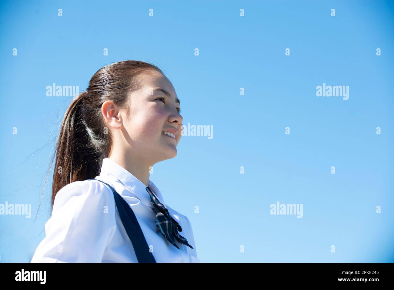 Schoolgirl in school uniform smiling in the distance Stock Photo - Alamy