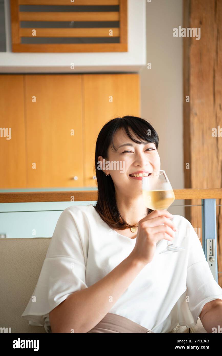 Woman laughing with a glass of wine at home Stock Photo - Alamy