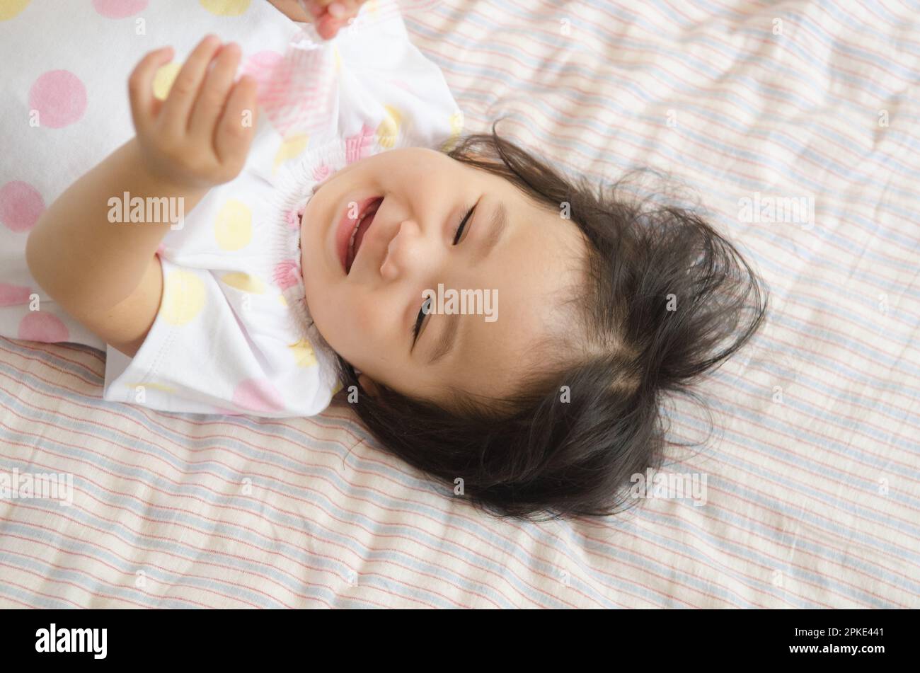 Girl laughing on bed Stock Photo