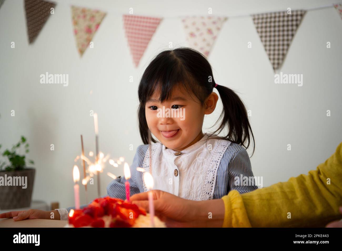 Girl looking at cake candles Stock Photo