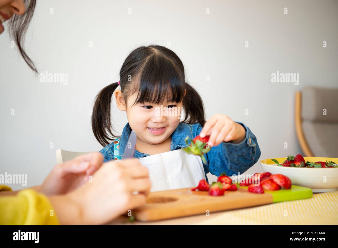 Girl cutting strawberries Stock Photo