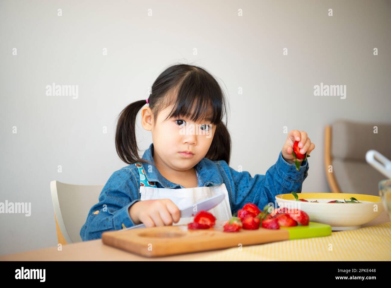Girl cutting strawberries Stock Photo