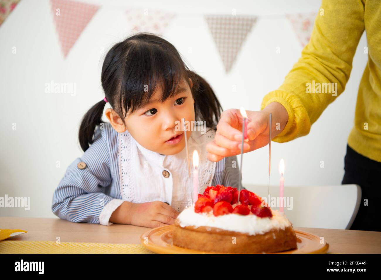 Girl looking at a cake candle Stock Photo
