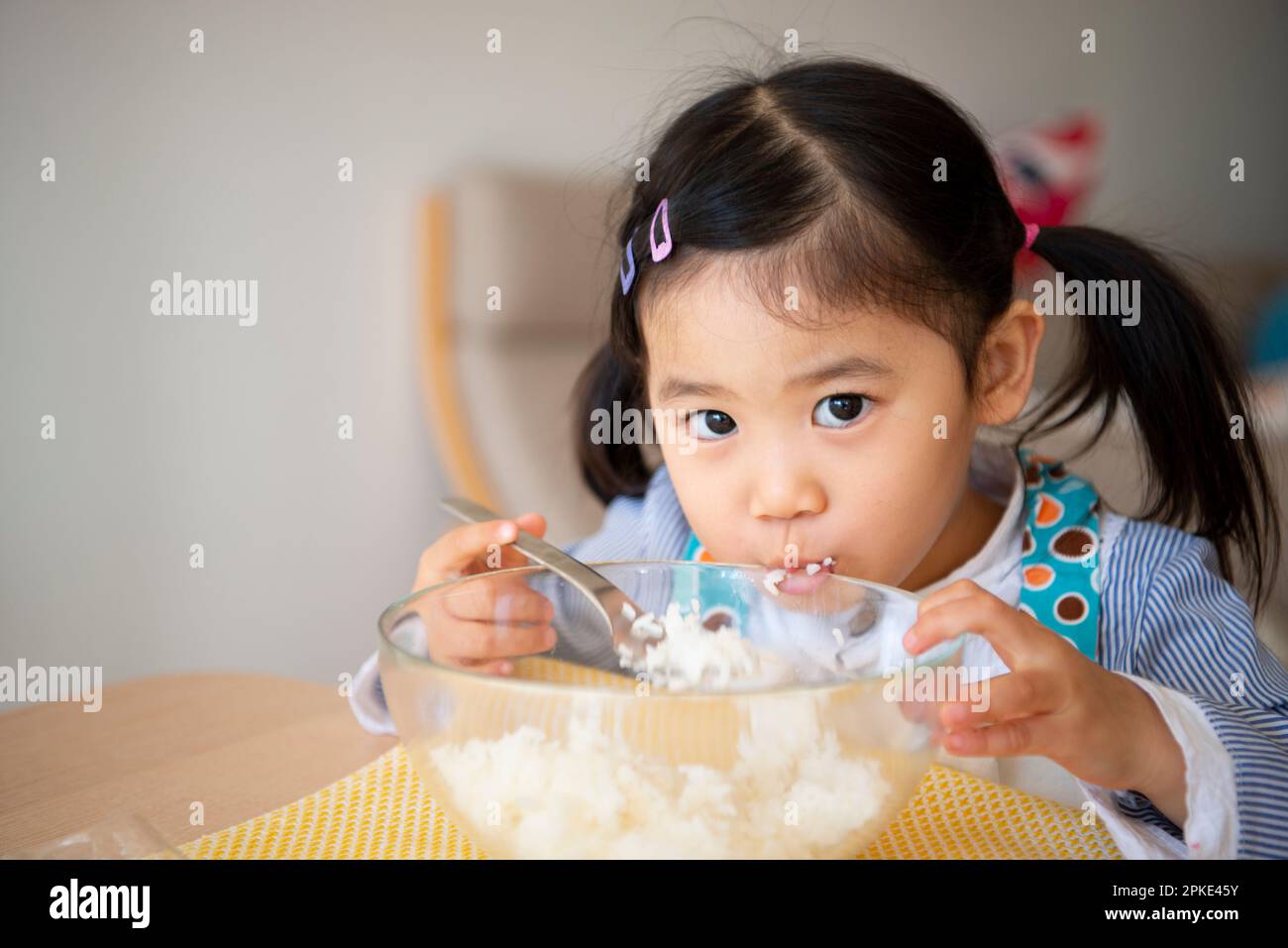 Girl eating rice Stock Photo