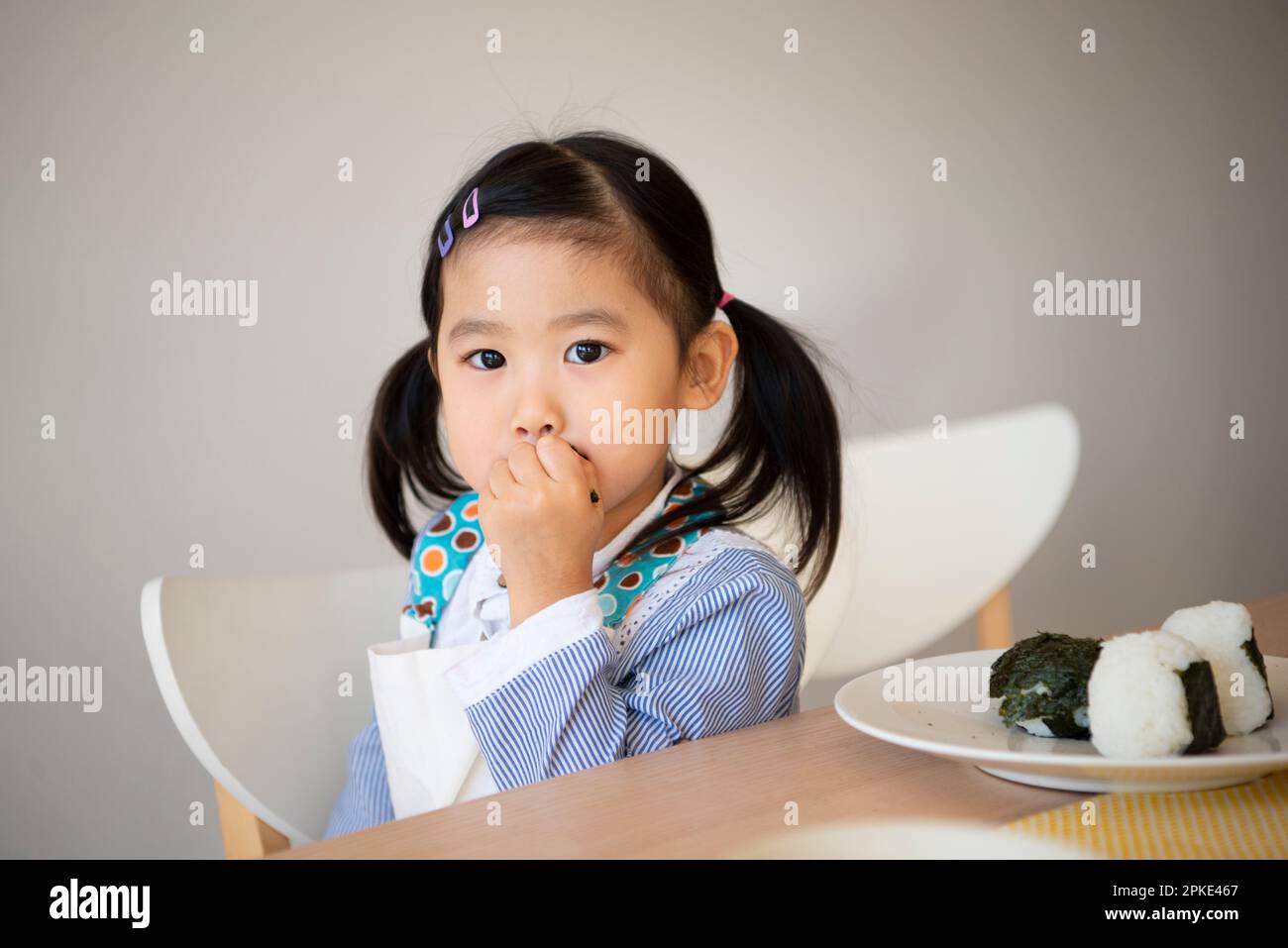 Girl eating onigiri Stock Photo