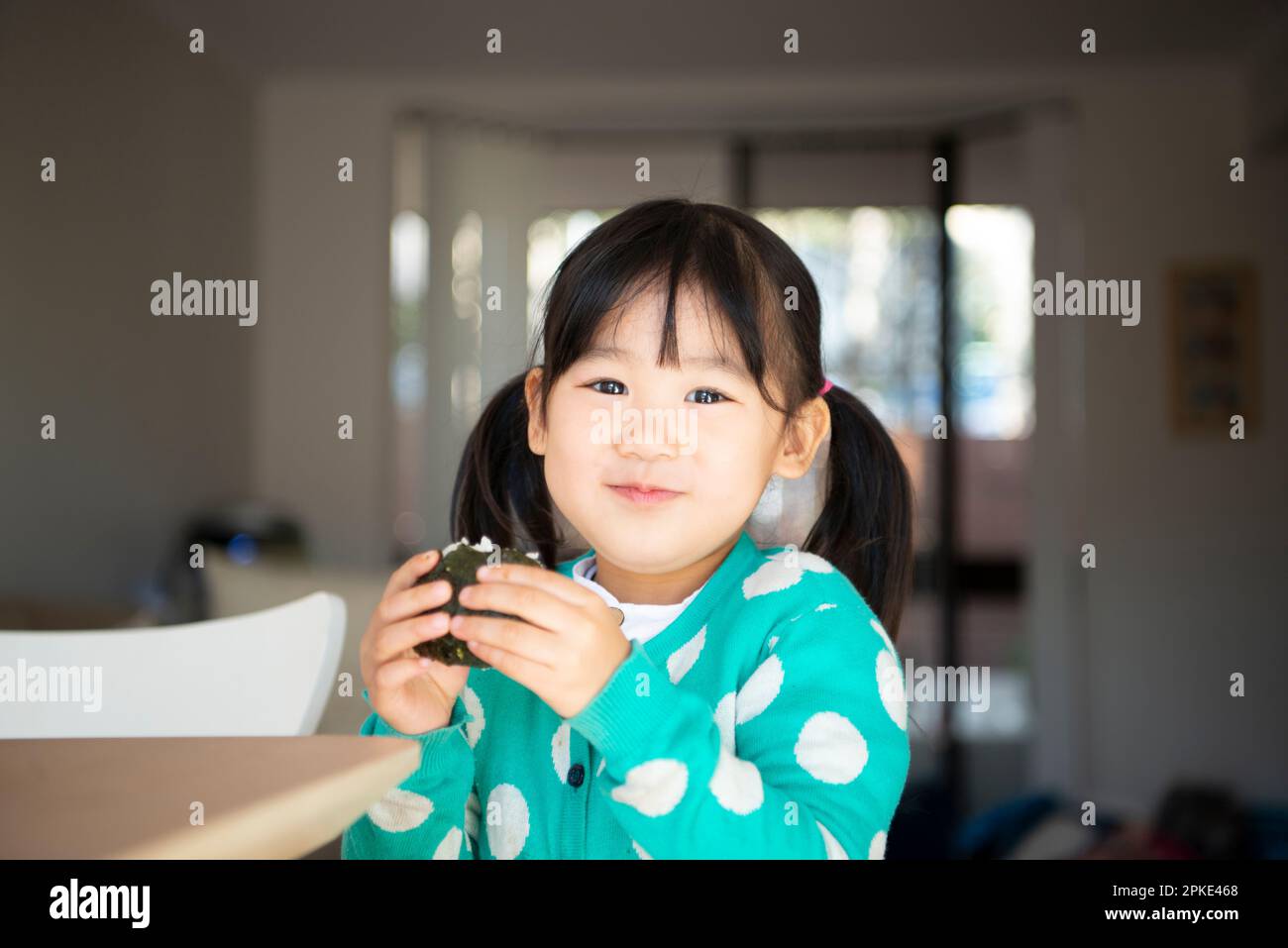 Girl eating onigiri Stock Photo