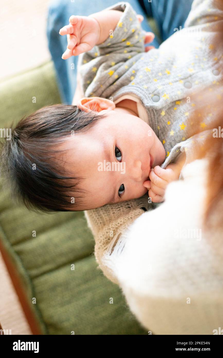 Baby being carried by mother Stock Photo