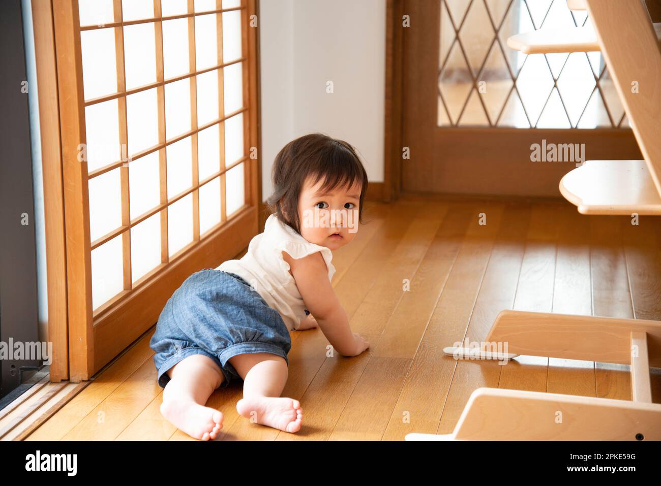 Baby crawling on wooden floor Stock Photo