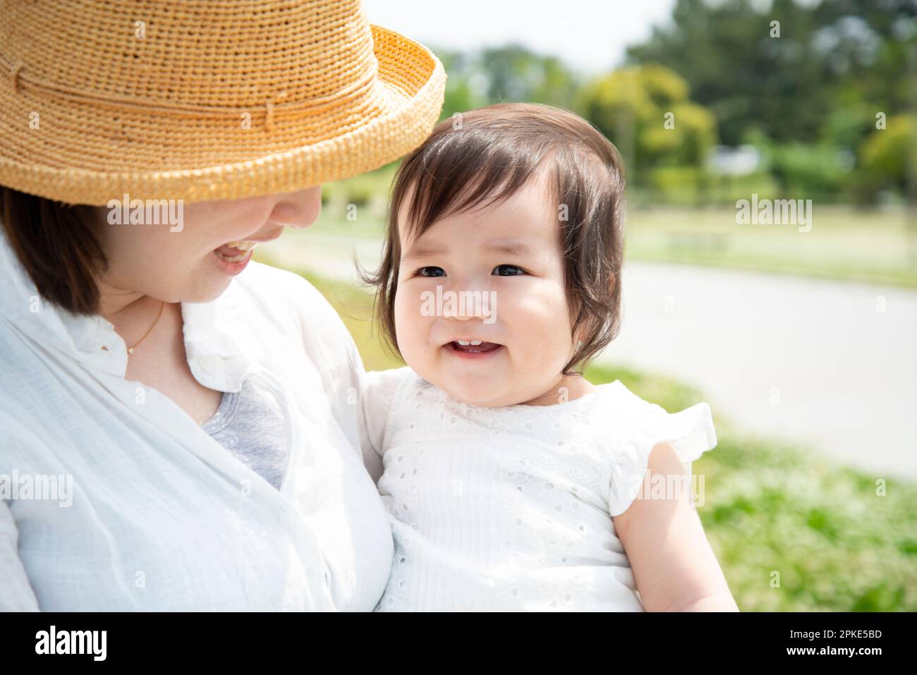 Laughing baby being carried by mother Stock Photo