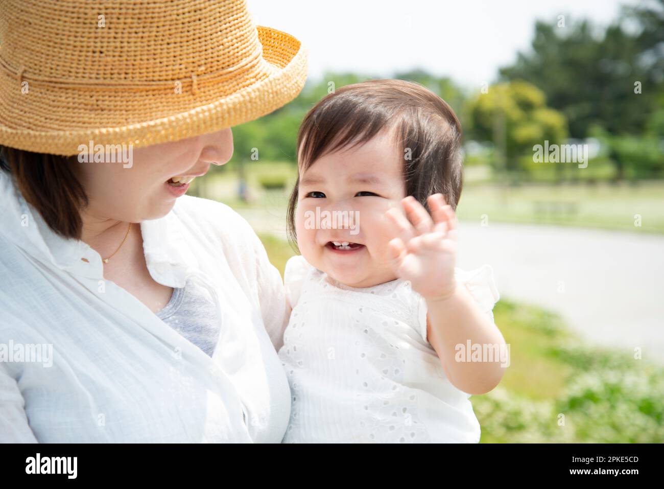 Laughing baby being carried by mother Stock Photo