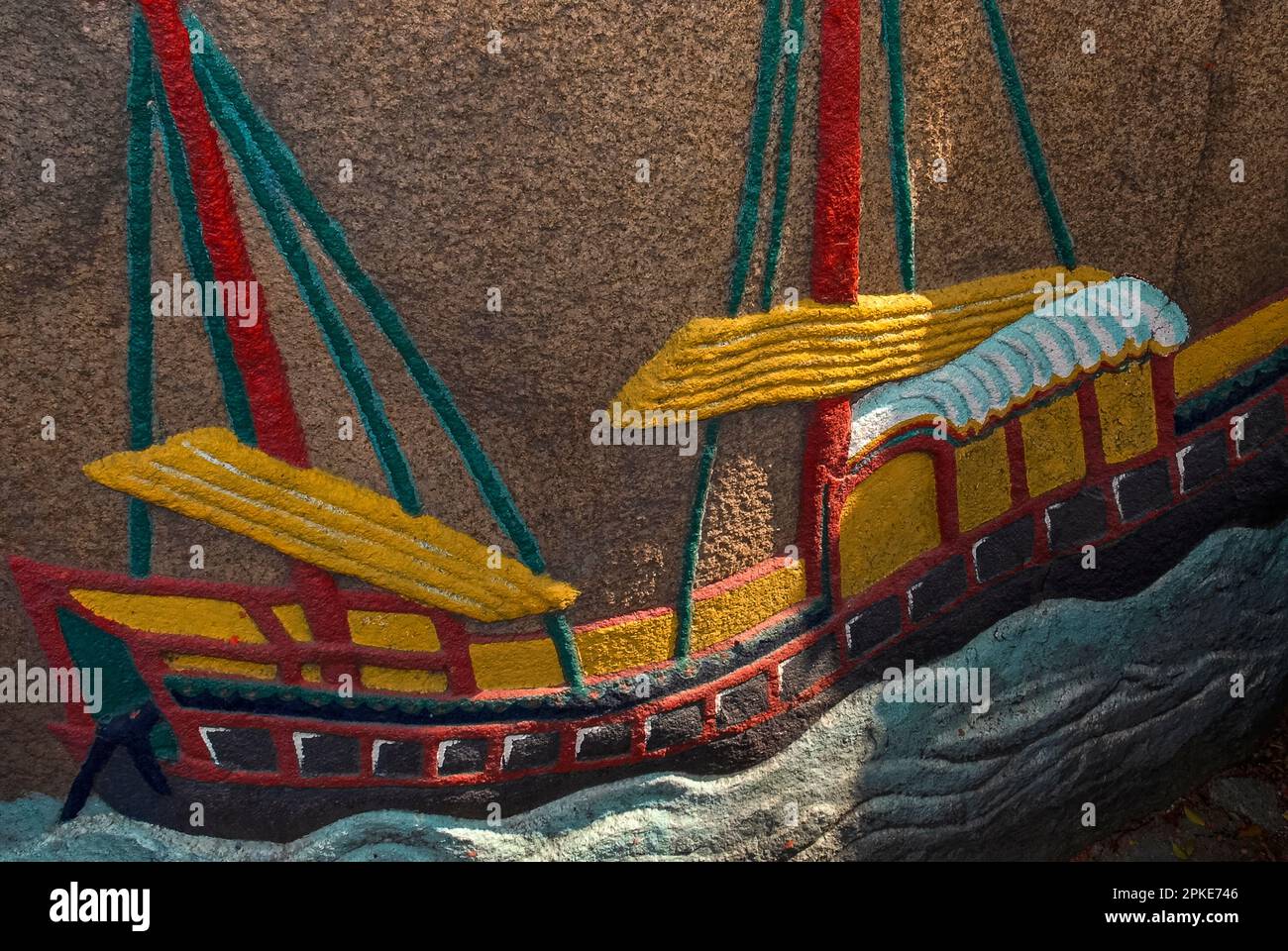 A lorcha, a triple-masted ship with a European hull and the sails and rigging of a Chinese junk, depicted in a colourful bas-relief on a granite boulder before the A-Ma Temple in Macau, China.  It represents the vessel of a poor fisherman who carried A-Ma, Taoist mother-goddess and protector of seafarers, to safety after a storm.  The temple, dating from 1488 AD, was built on the spot where she landed. Stock Photo