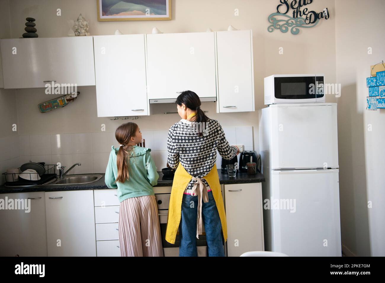 Parent and child standing in the kitchen Stock Photo