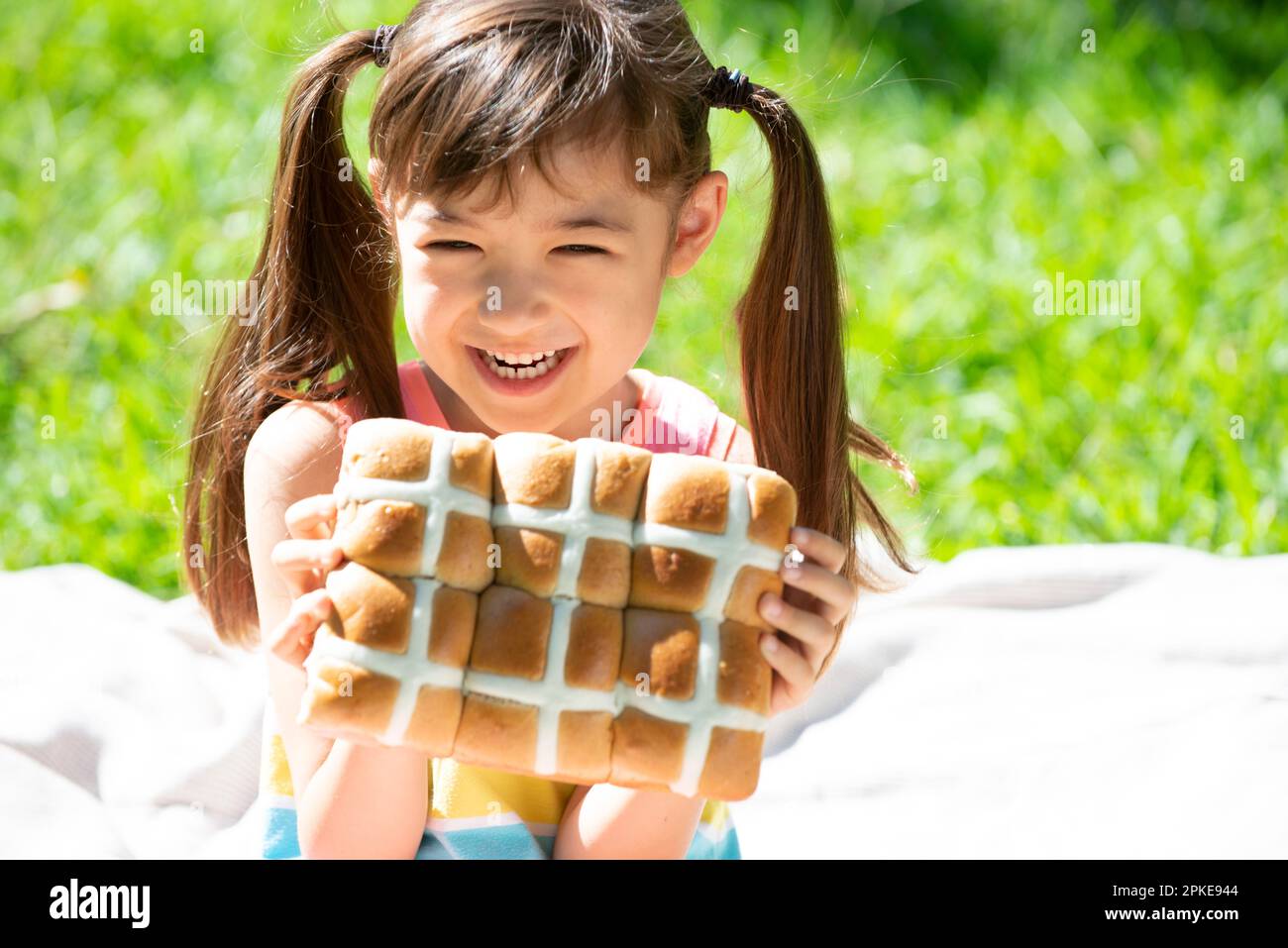 Girl holding Easter hot cross buns Stock Photo
