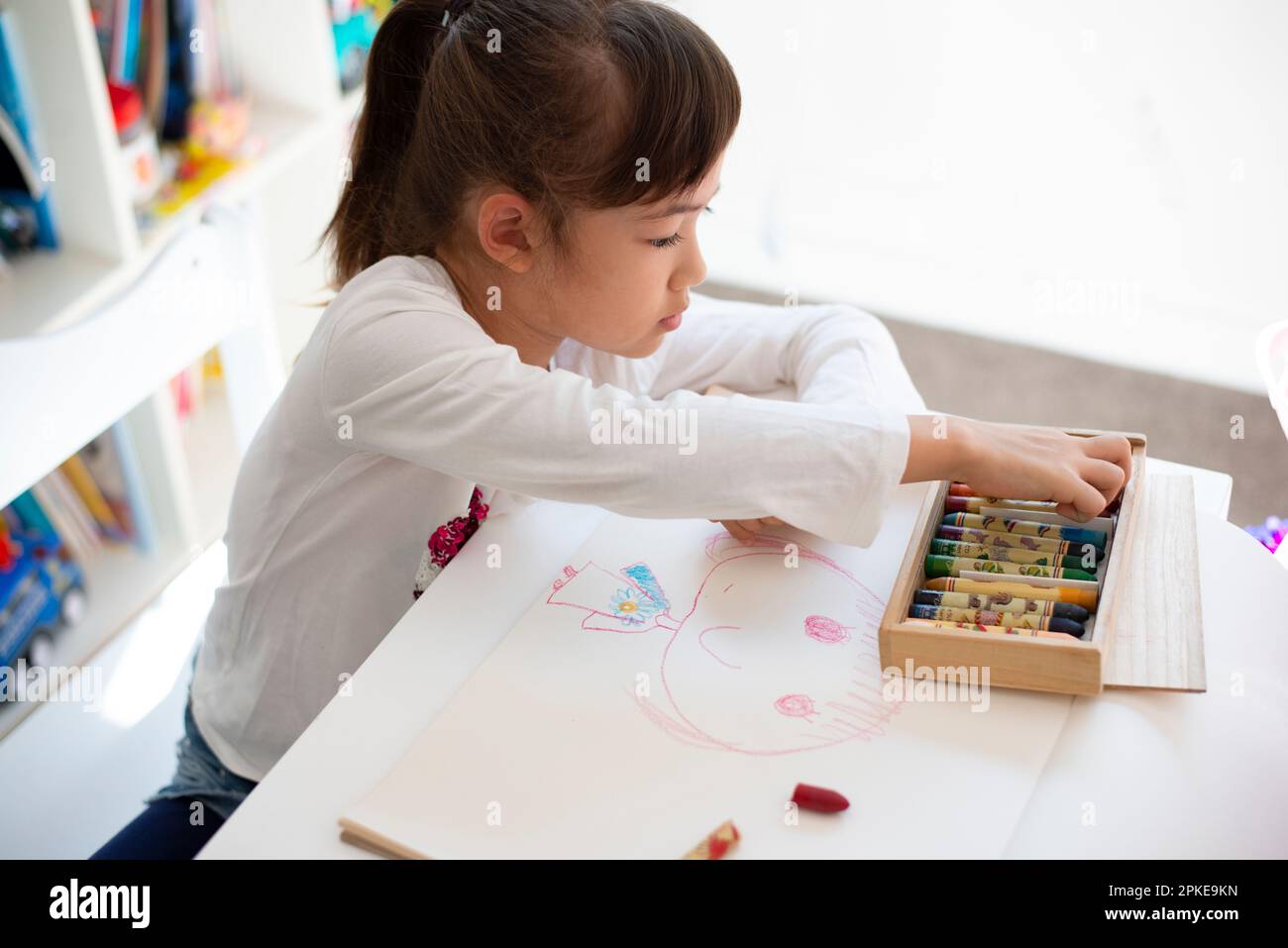 Girl drawing with crayon Stock Photo - Alamy