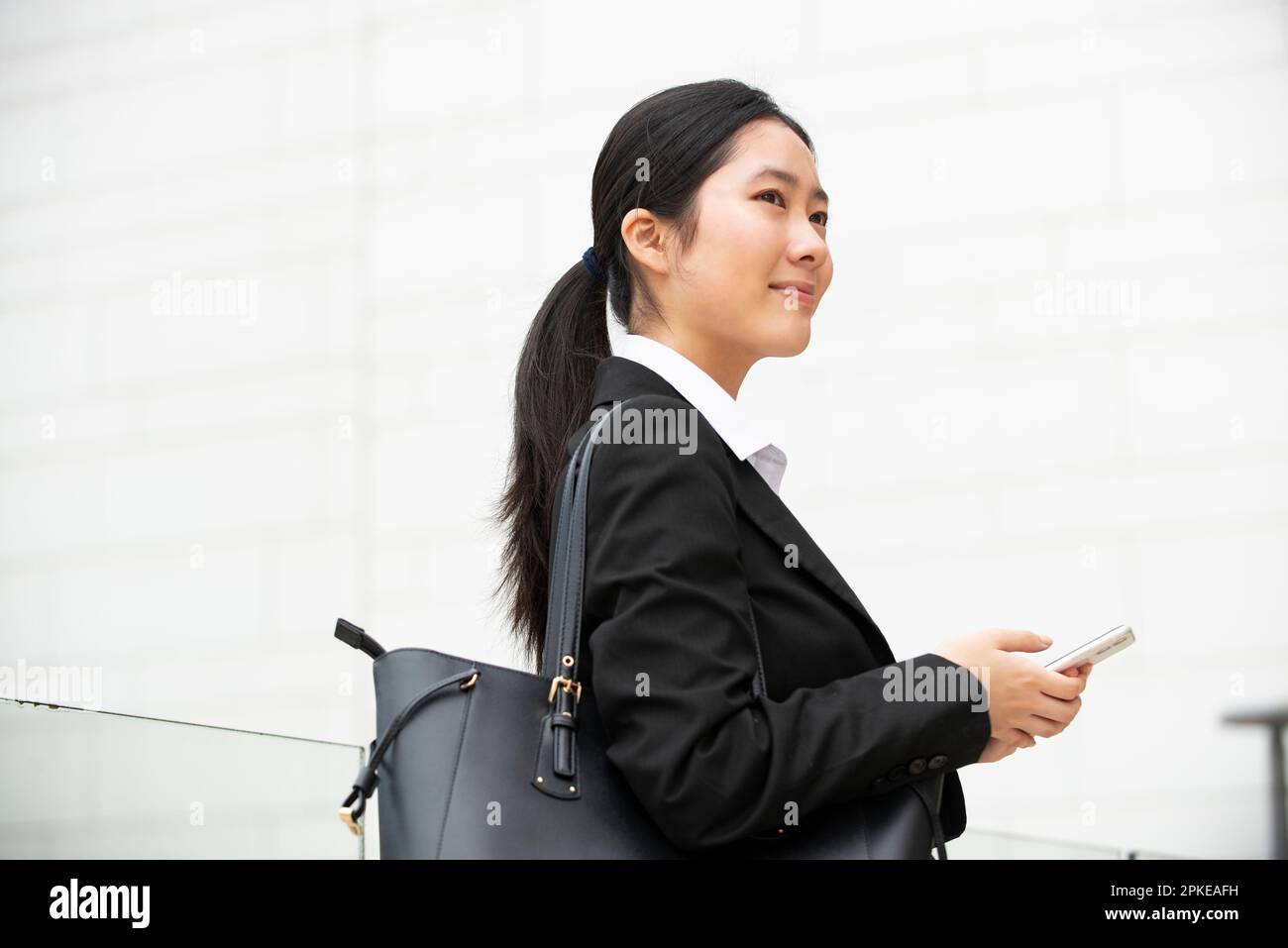 Woman in suit holding phone Stock Photo