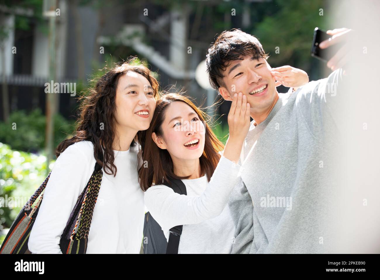 Three students taking selfies with smiles on their faces Stock Photo