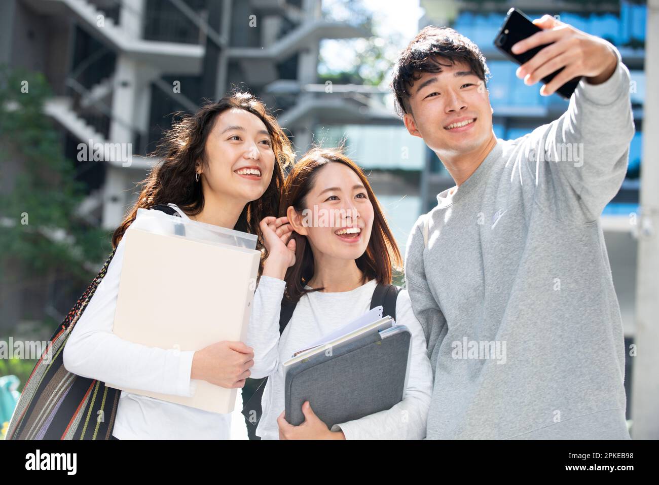 Three students smiling and taking selfies Stock Photo