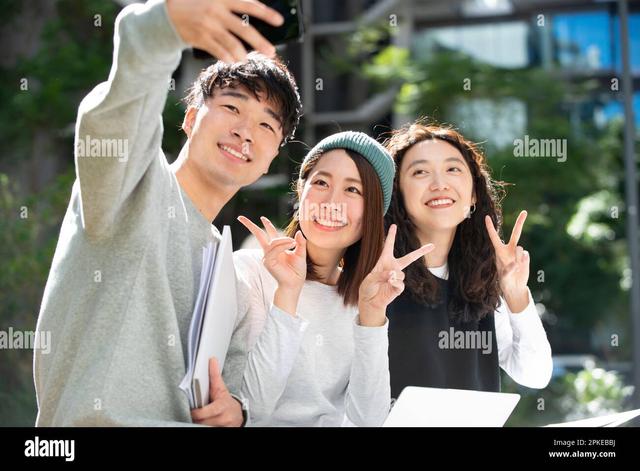 Three students smiling and taking selfies Stock Photo
