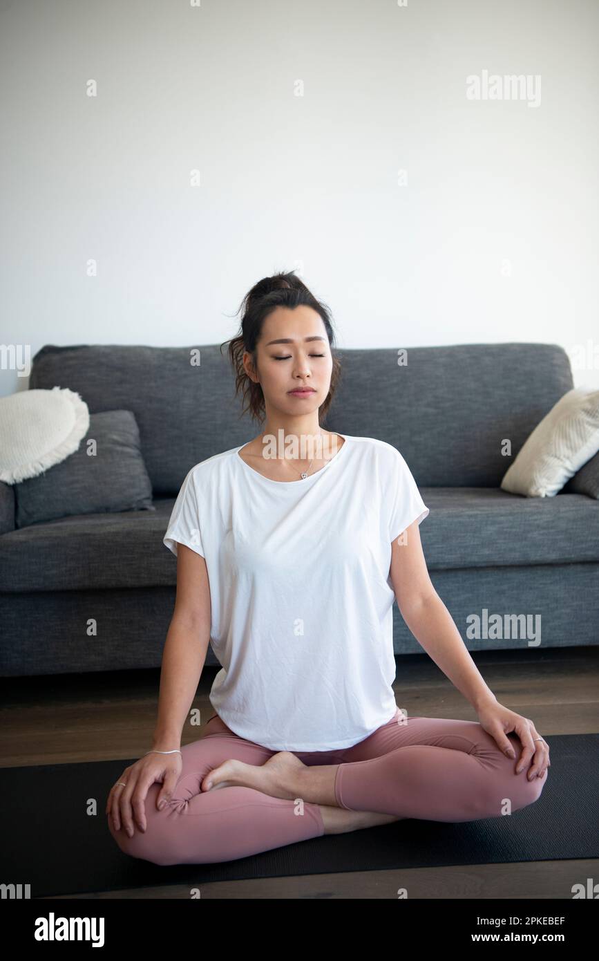 Woman meditating indoors Stock Photo