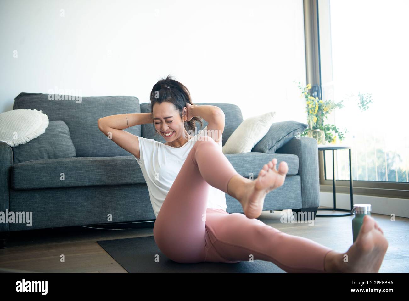 Woman exercising indoors with a smile on her face Stock Photo