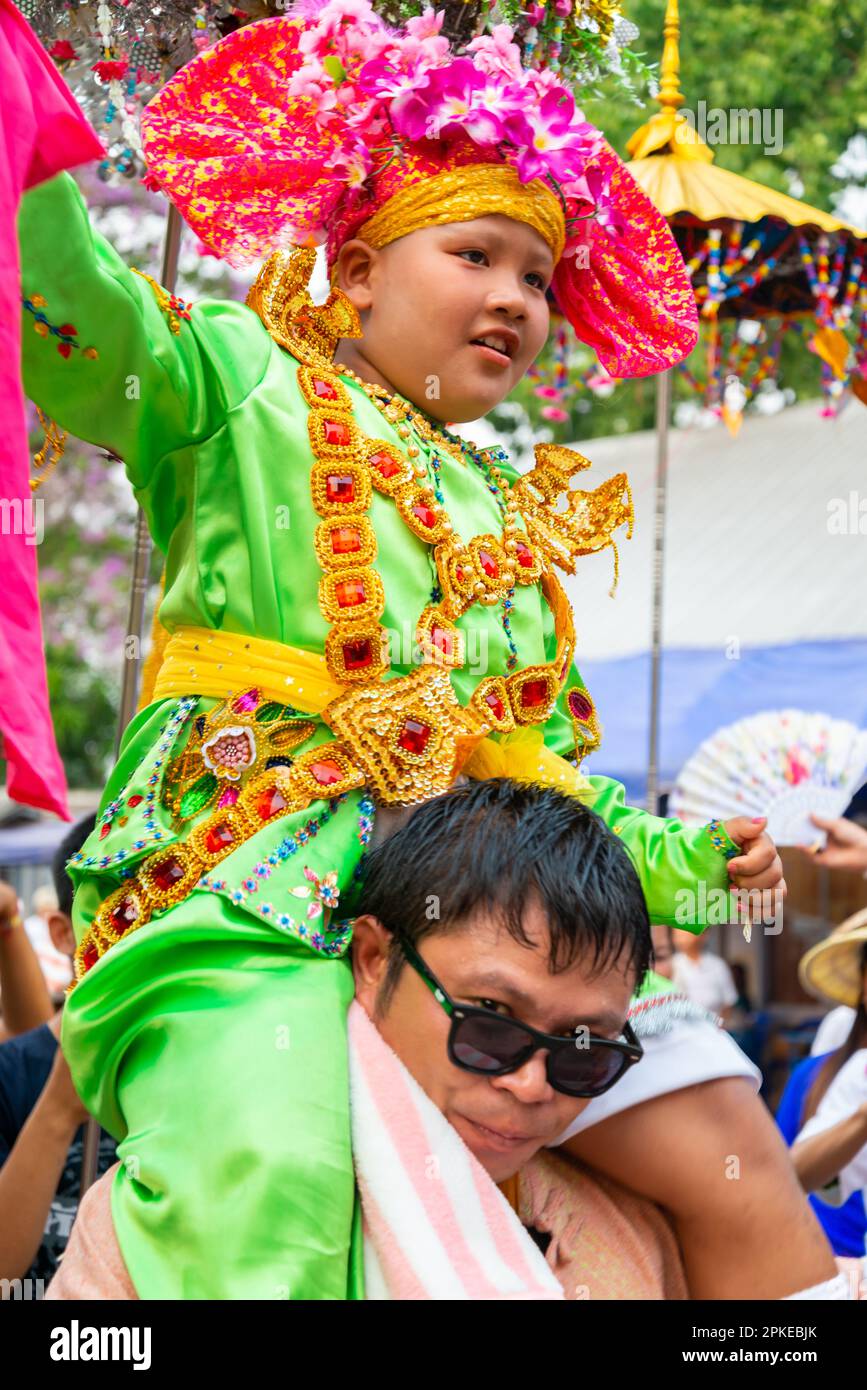 Pai,Mae Hong Son,Thailand-April 3rd 2023:Boys,aged between seven and fourteen years,about to be ordained as Buddhist monks,are carried on men's should Stock Photo