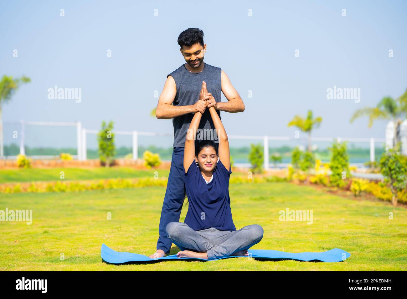 Trainer teaching yoga pose or posture to girl at park concept of yoga