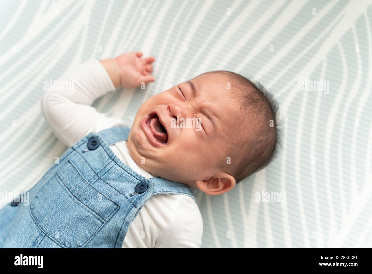 Baby crying on the floor Stock Photo