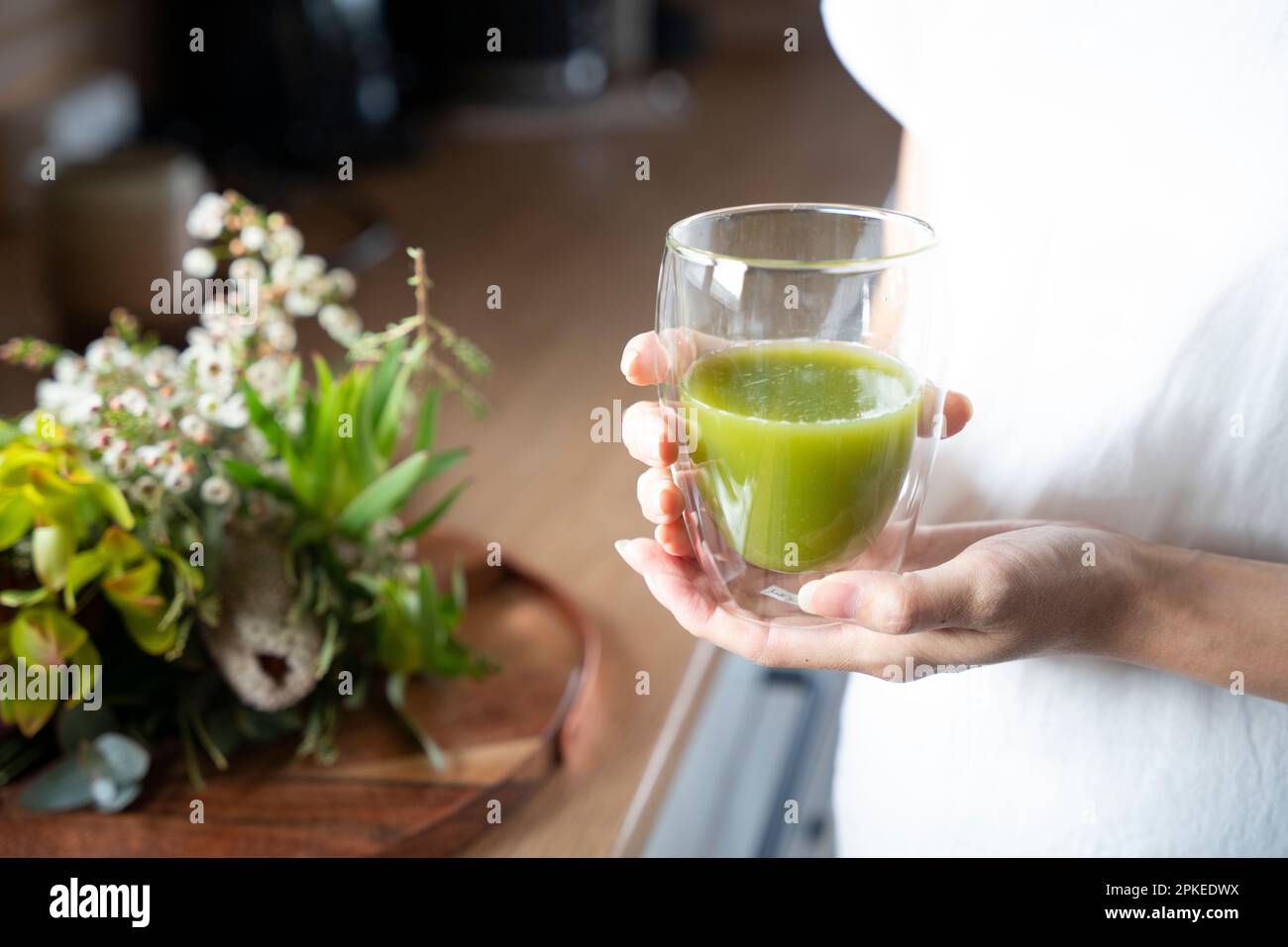 A woman holding a smoothie in her hand Stock Photo