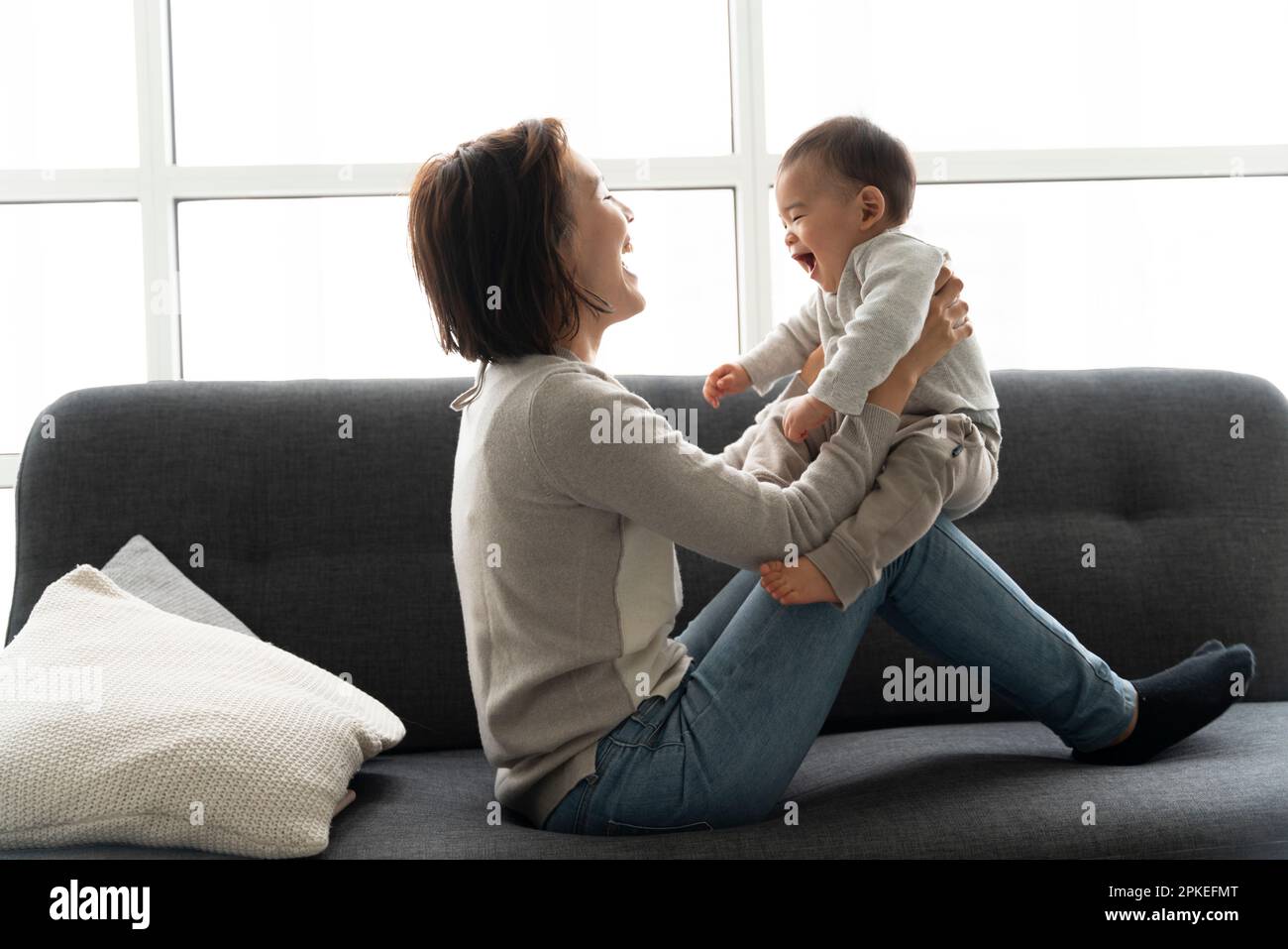 Mother nursing her baby on the couch Stock Photo