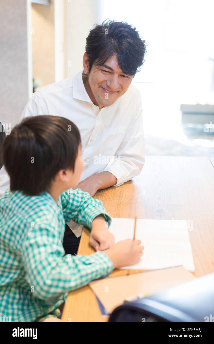 Smiling boy writing notebook home hi-res stock photography and images ...