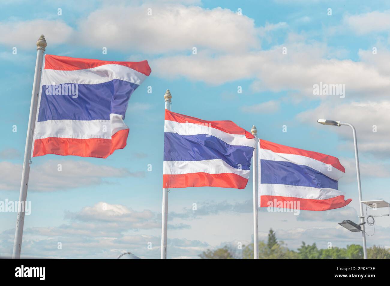 thailand flag. Image of waving three Thai flags of Thailand with blue sky background. Thailand flag waving in wind with beautiful blue sky Stock Photo