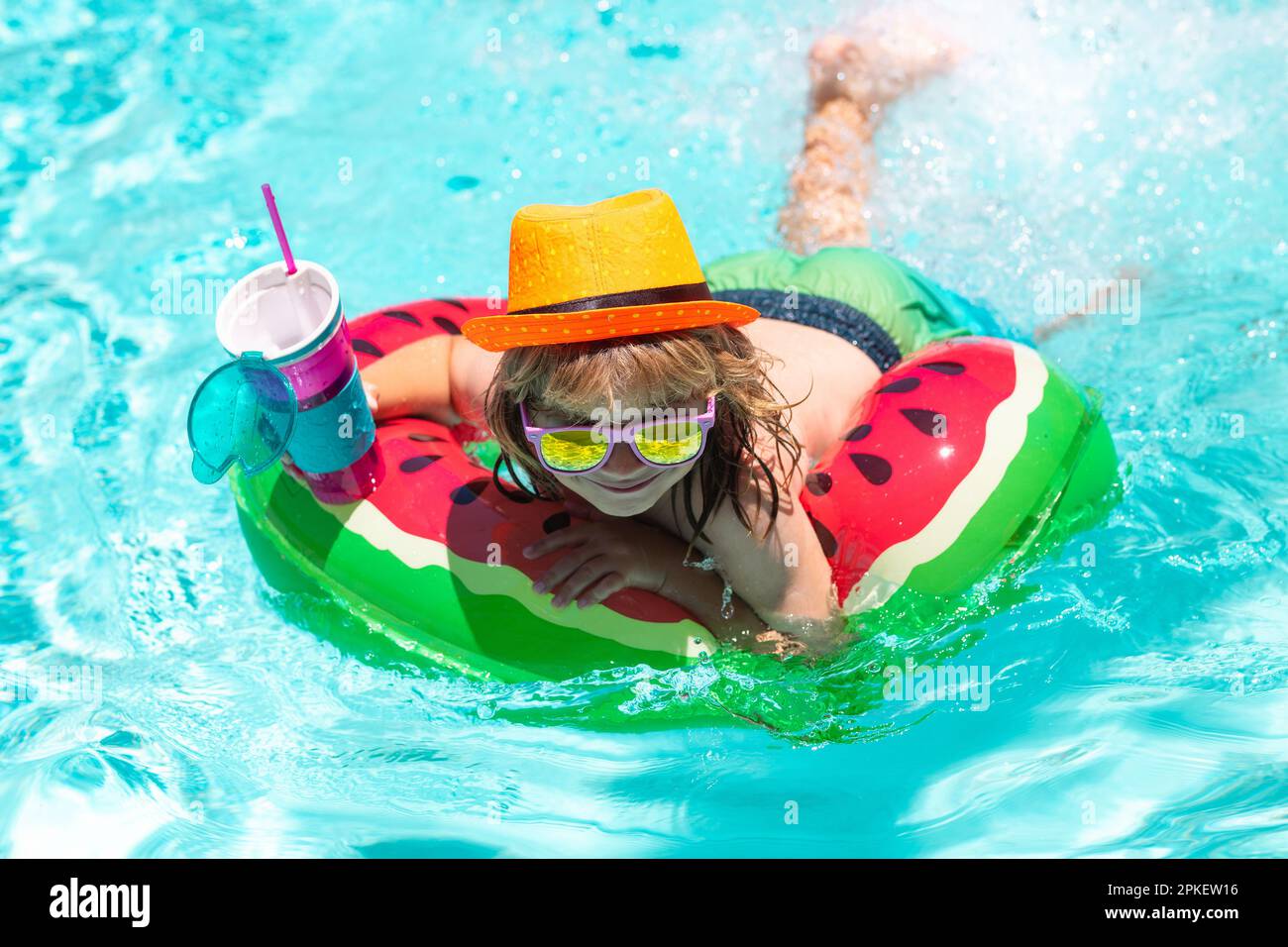 Happy child playing in swimming pool. Summer kids vacation. Child swim