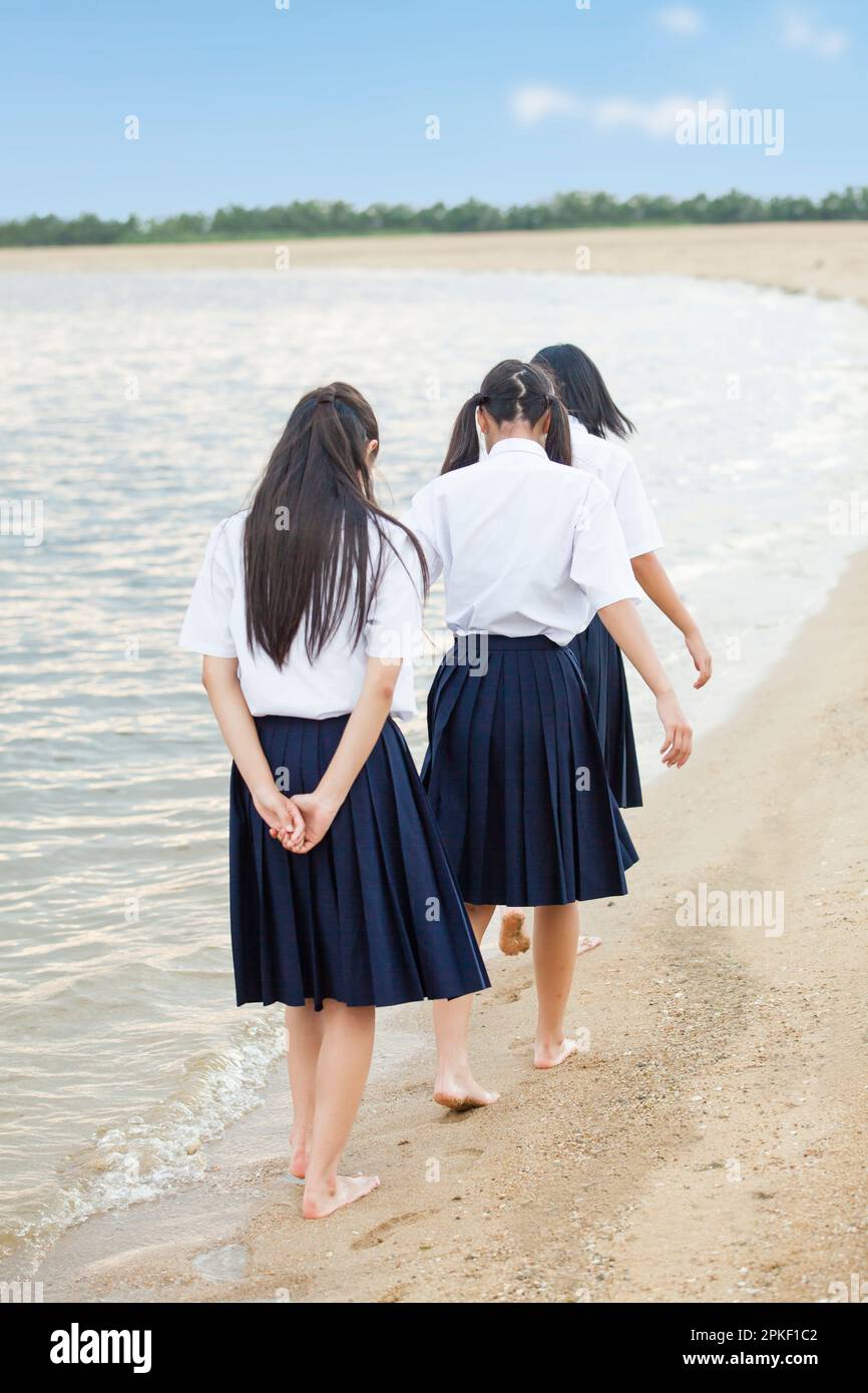Junior high school students walking on the beach Stock Photo
