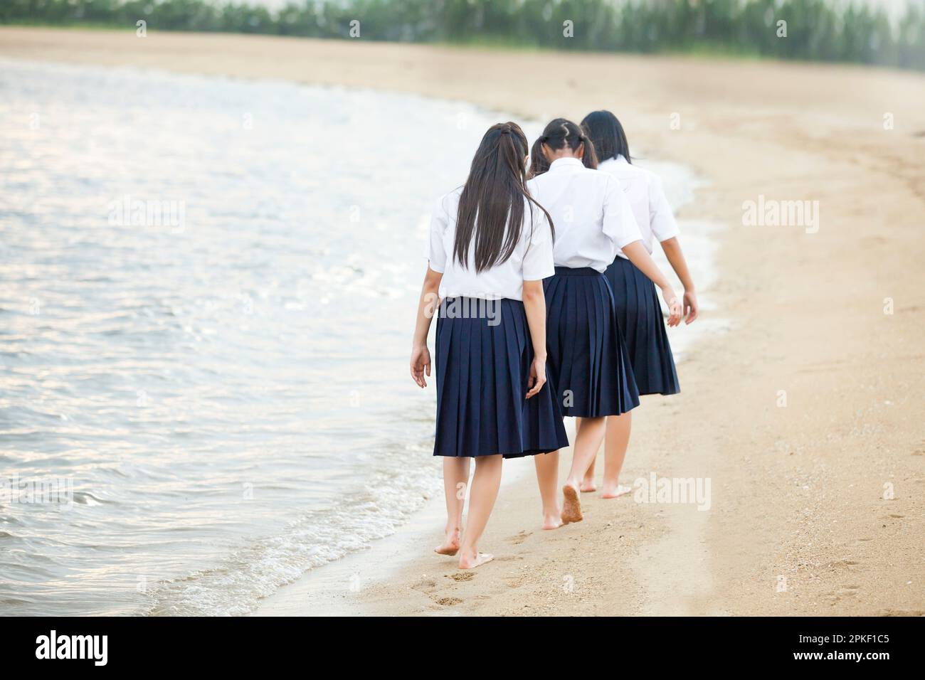 Junior high school students walking on the beach Stock Photo