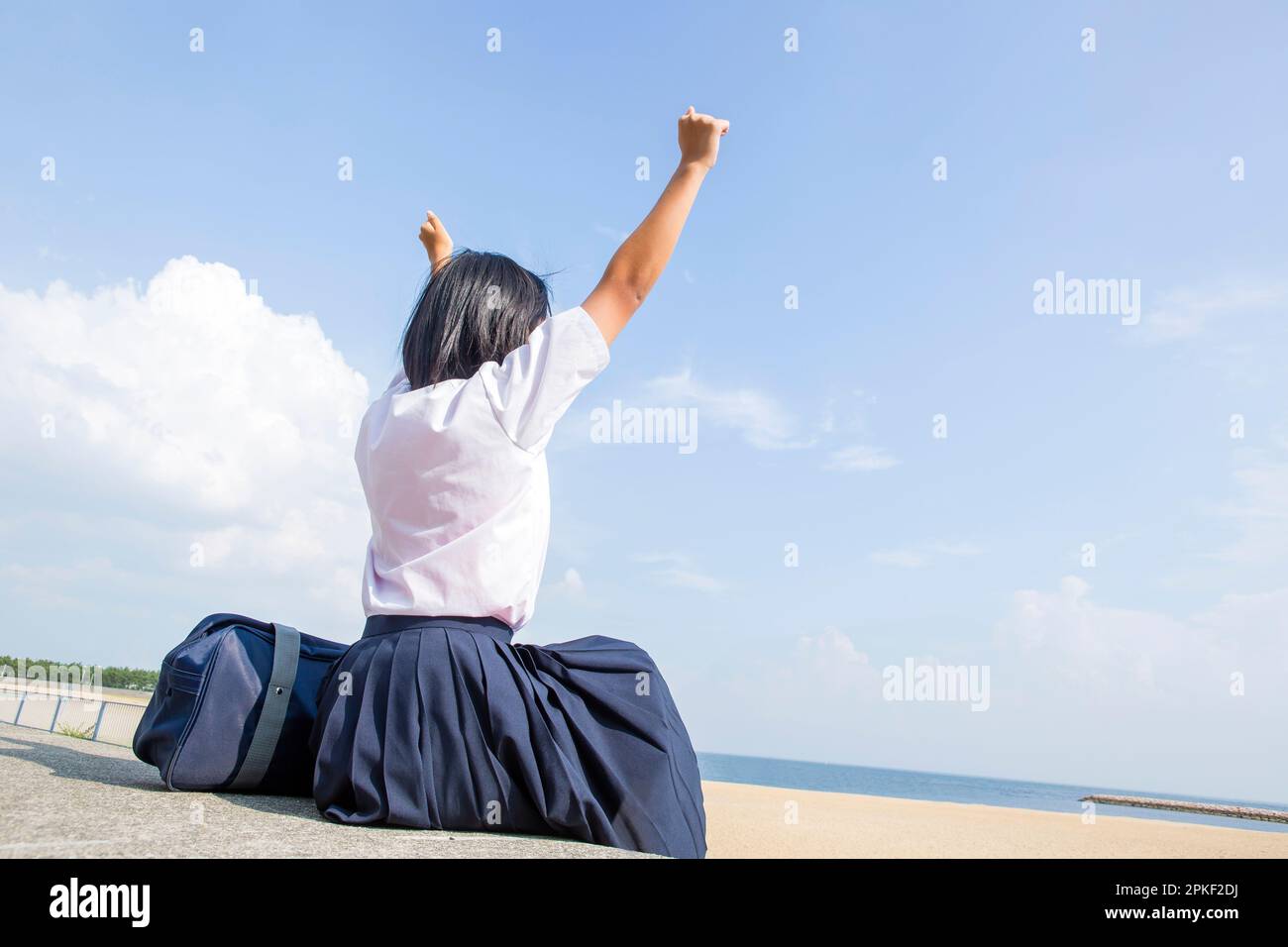 Junior High School Students Stretching While Sitting on the Embankment Stock Photo