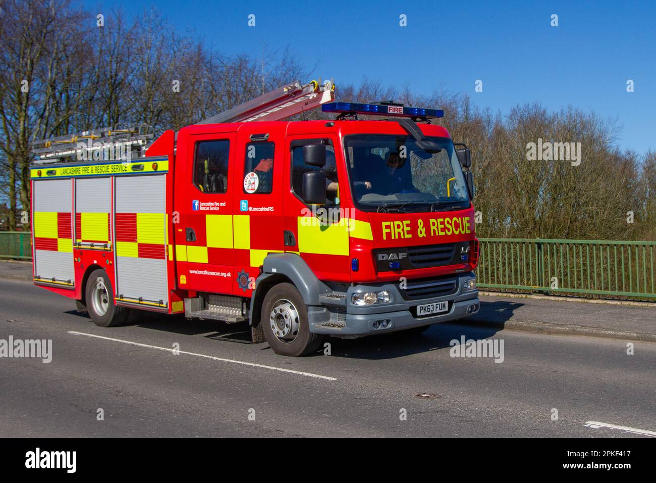 Lancashire Brigade Fire & Rescue service DAF LF Crew Cab; crossing motorway bridge in Greater Manchester, UK Stock Photo